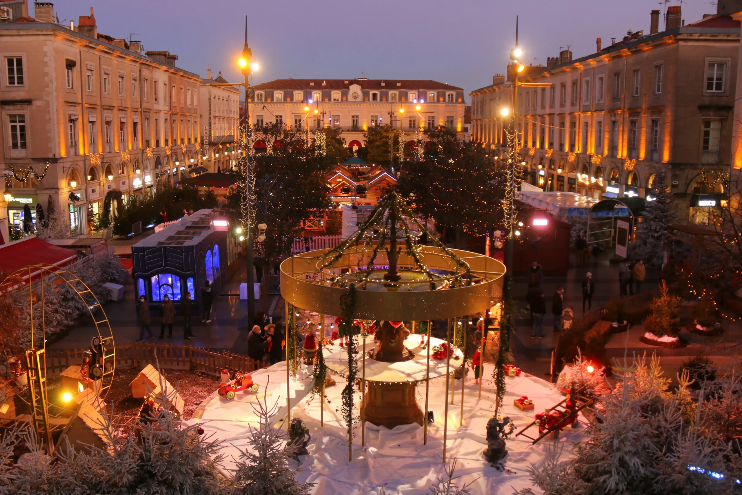 Photo du marché de noël, ou l'on voit les chalets et la fontaine au premier plan décoré