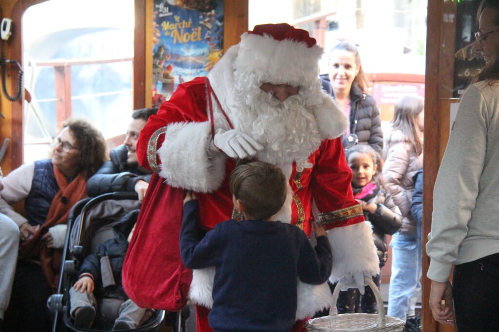 Père Noel prenant dans ses bras un enfant